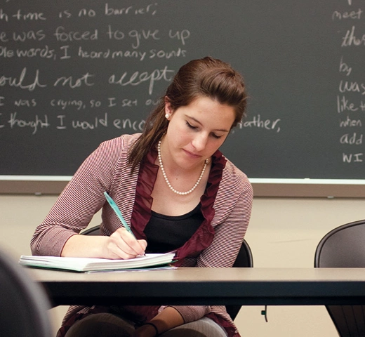 student writing at a desk