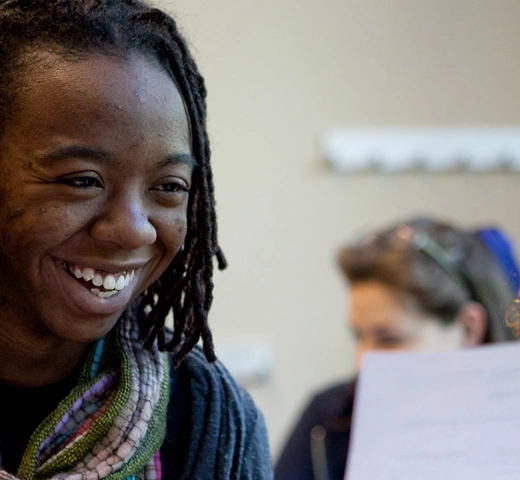 Two students reviewing a document. One student is smiling.