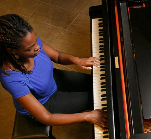 Student playing a grand piano
