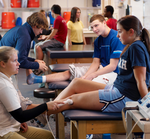 student helping someone put a wrist guard on