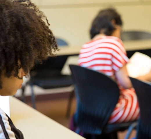 Students in a classroom writing. 
