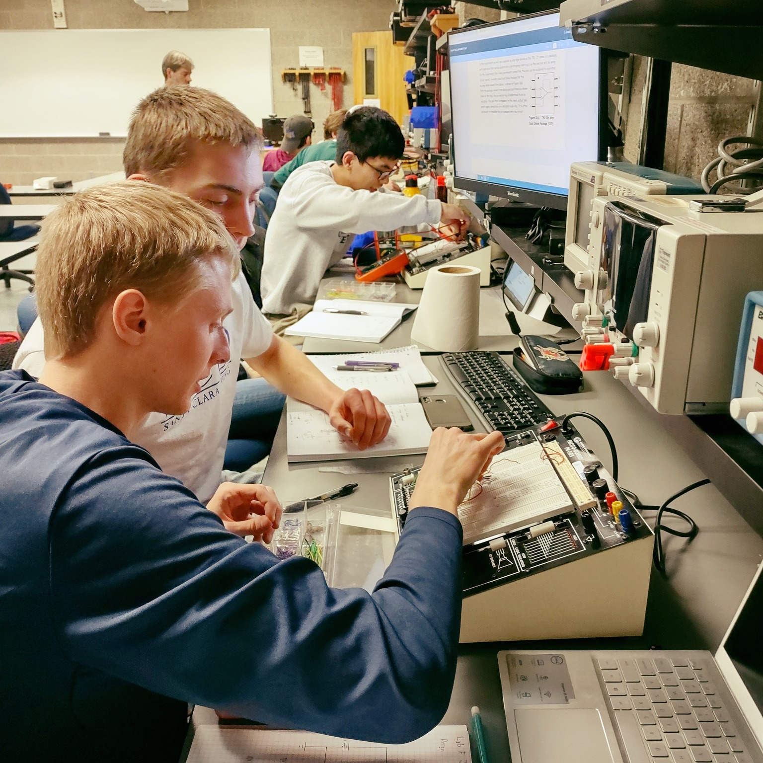 Students work together on a circuit project in the lab.
